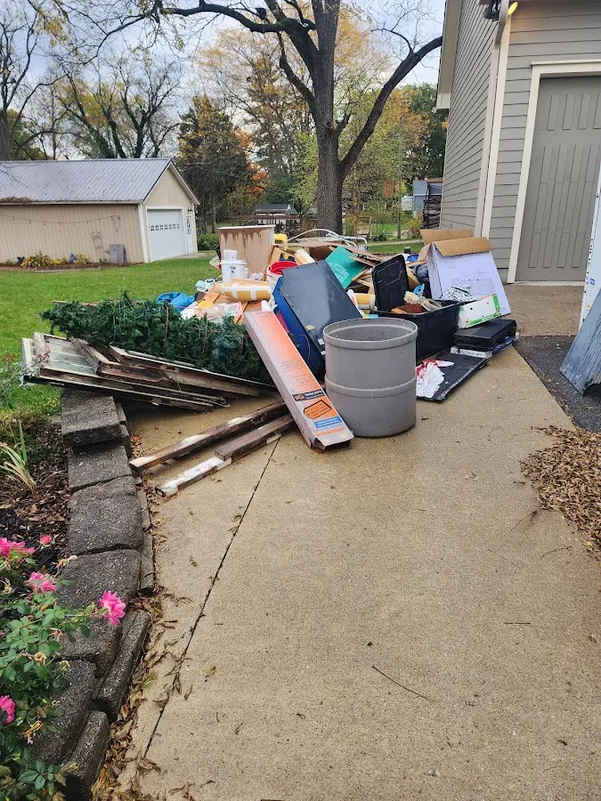 Dumpster being loaded with debris for 12 Yard Dumpster Rental in Grayling